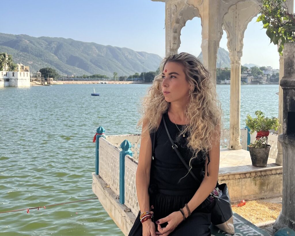 Vista sul lago sacro di Pushkar in Rajasthan con padiglione tradizionale e montagne sullo sfondo