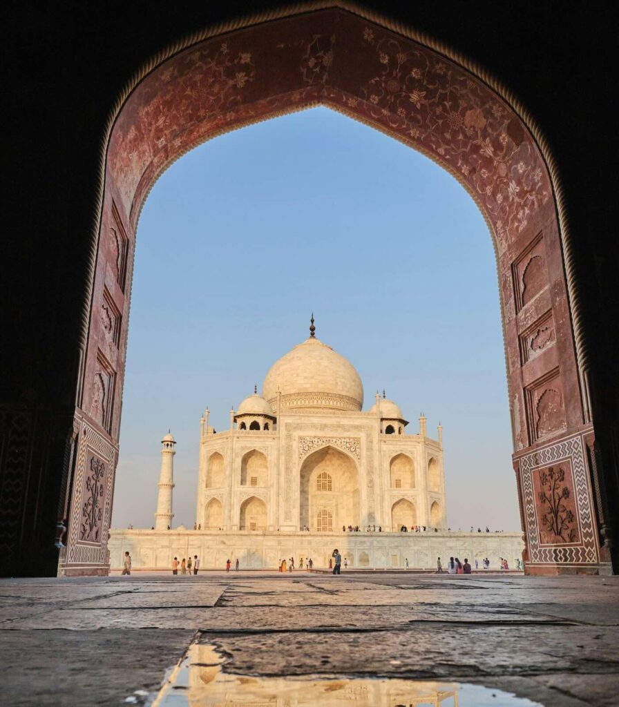 Porta del Taj Mahal ad Agra con il Taj Mahal incorniciato dall’arco e riflesso nell’acqua