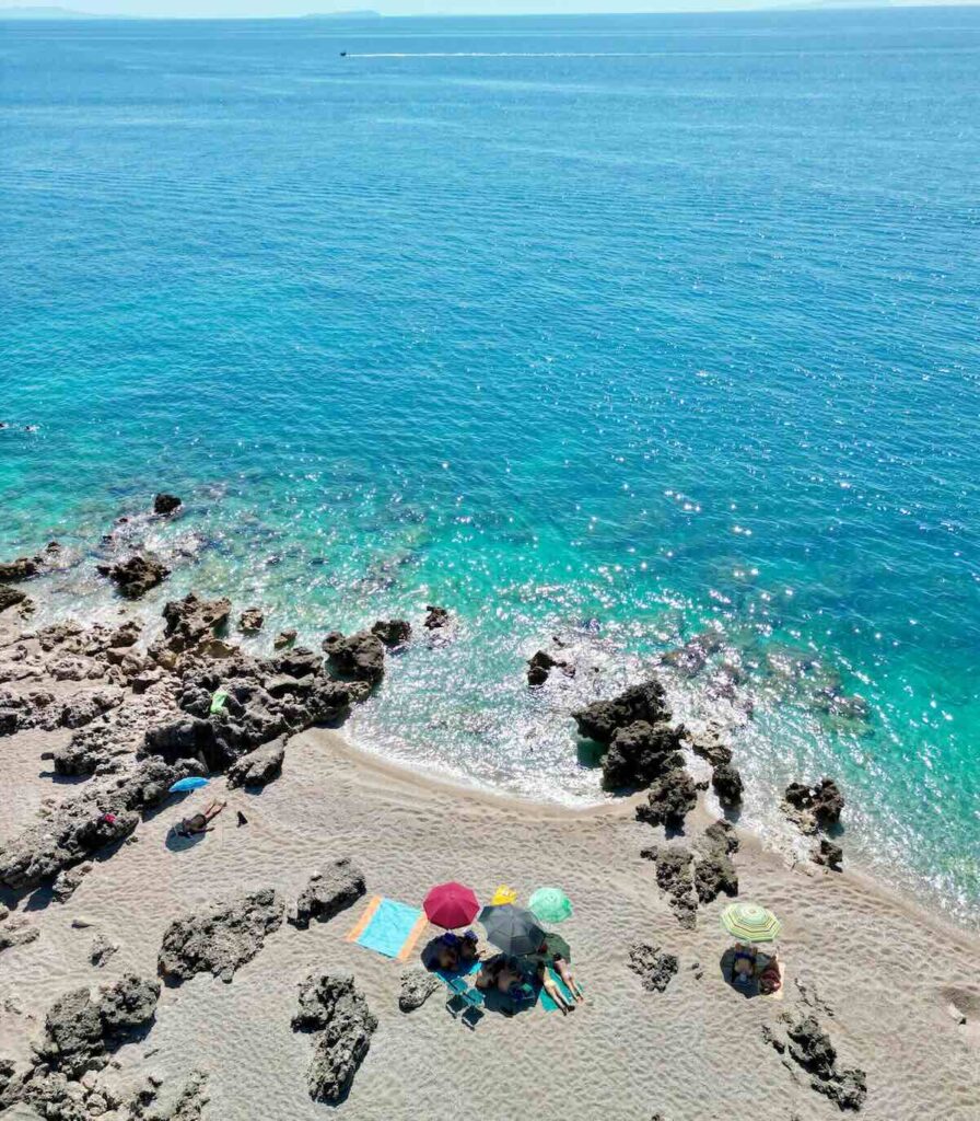 Gjipe Beach sulla Riviera Albanese con mare cristallino e scogliera